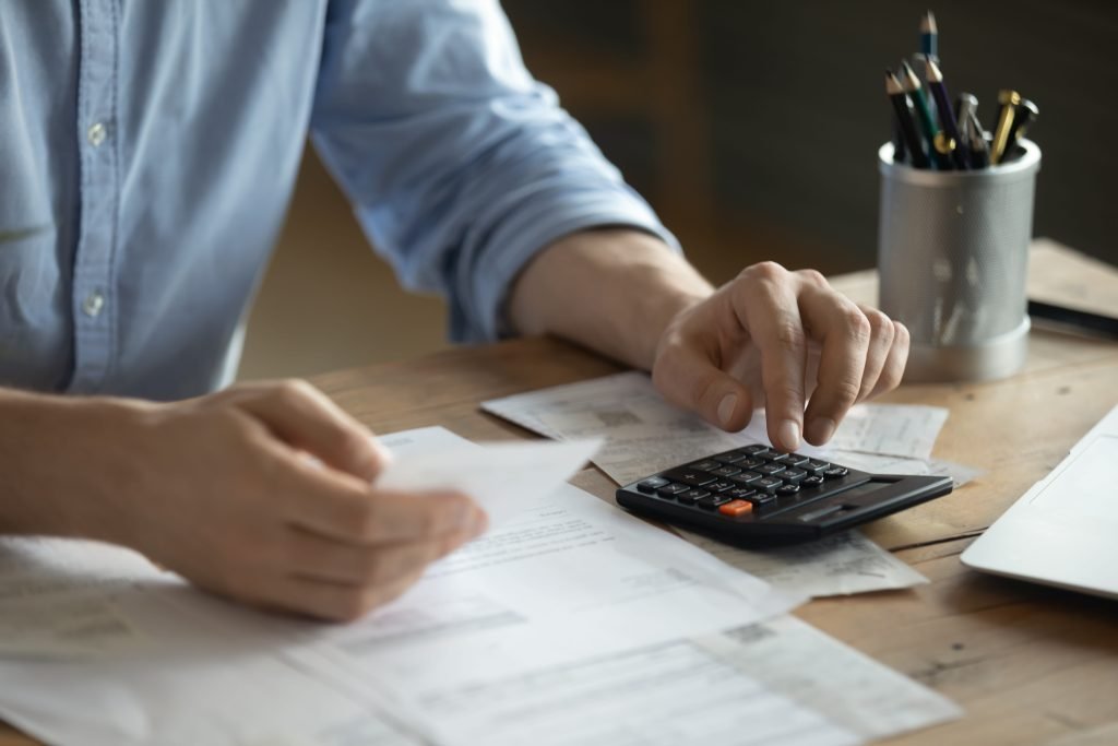 Person reviewing tax forms with a calculator for individual and business tax services
