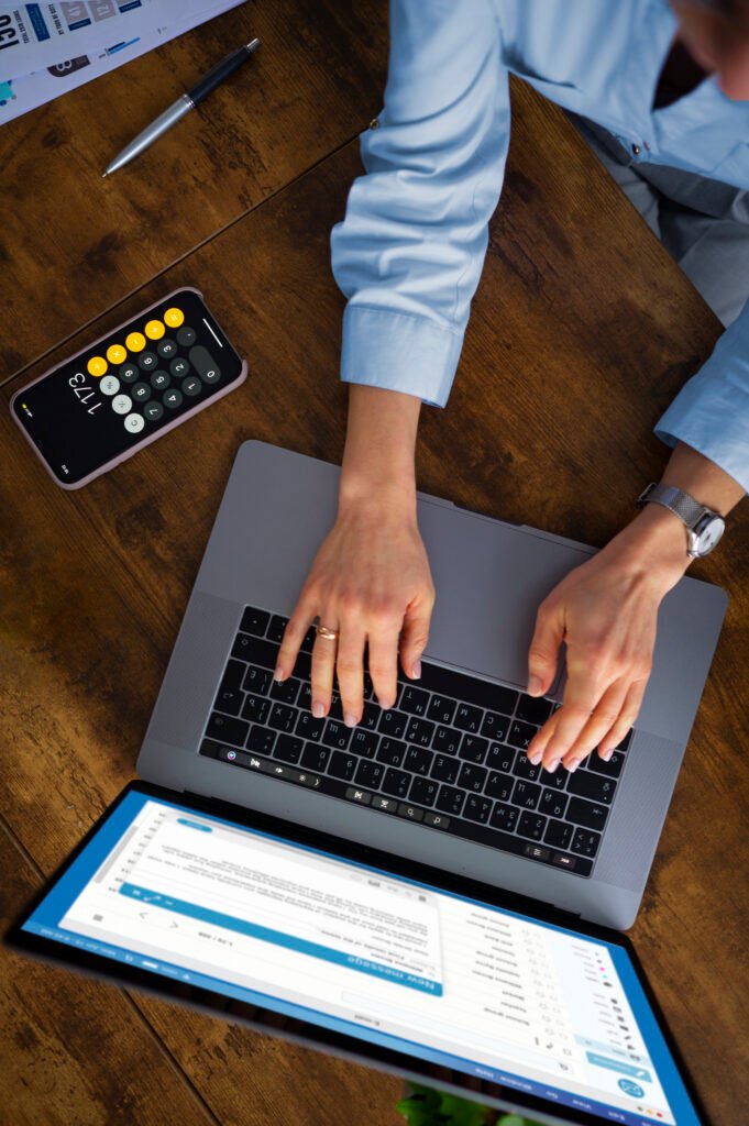 Business professional using a laptop to manage cloud-based payroll services for a small business.